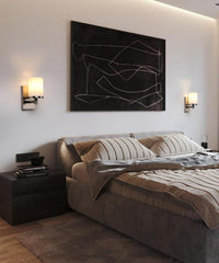 Modern bedroom with a bed, nightstands, and abstract wall art.