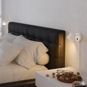 Modern bedroom with a black upholstered headboard and white bedding.