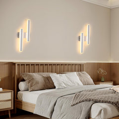 Modern bedroom with wooden bed, wall lights, and neutral decor.