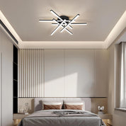 Modern bedroom with a ceiling light fixture and neatly made bed.