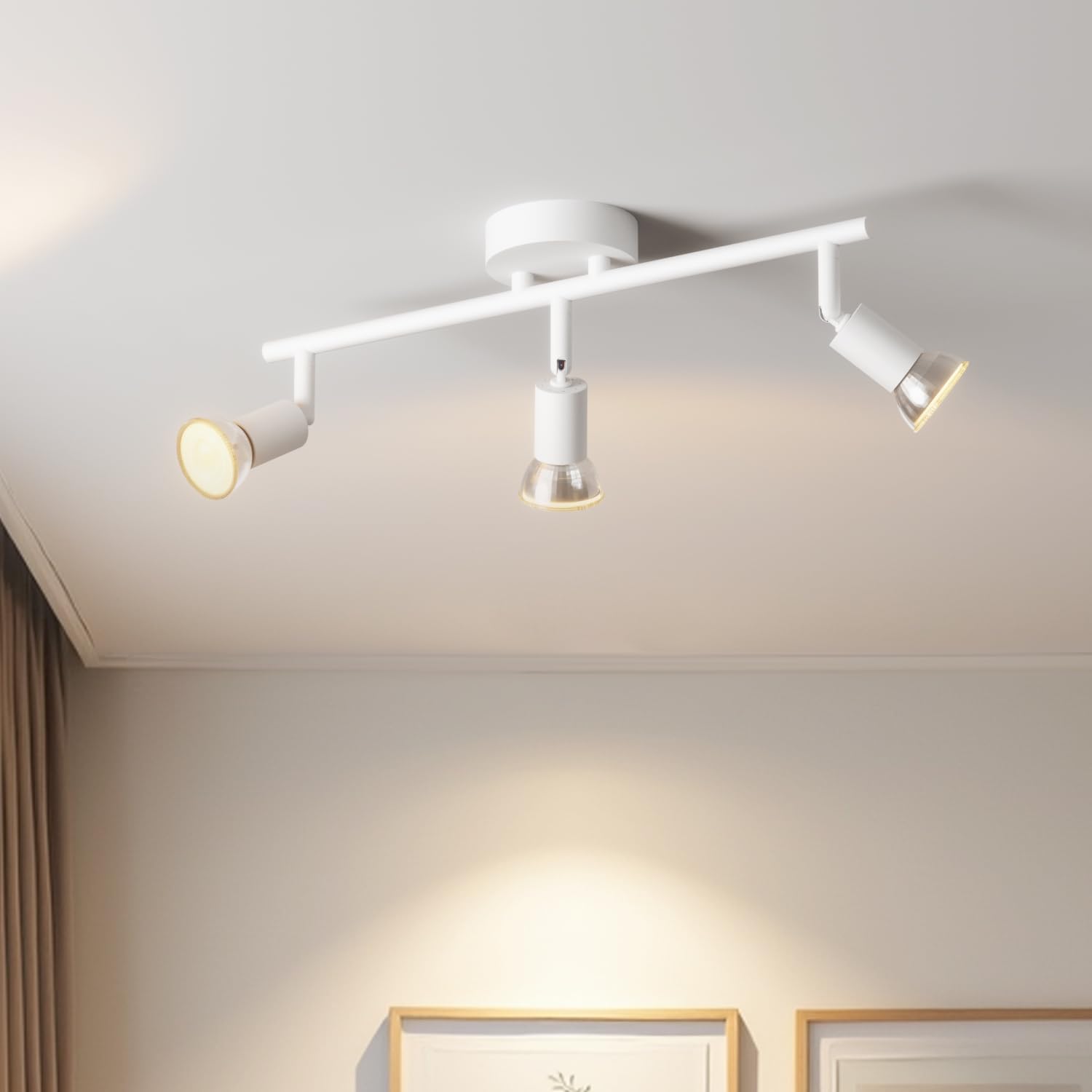 Modern ceiling light fixture with three lights on a neutral wall background