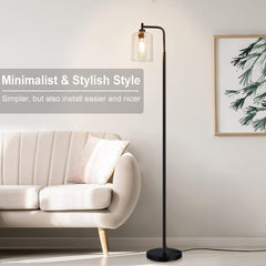 Modern floor lamp in a living room setting with a sofa and decorative wall art.