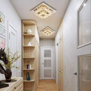Modern hallway with wooden shelves, decorative lights, and a door.