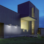 Modern house exterior at night with illuminated windows