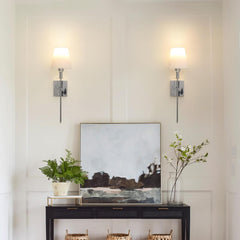 Modern interior with wall sconces, a console table, and decorative items.