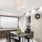 Modern kitchen with dining table and chairs, featuring a clock on the wall.