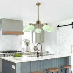 Modern kitchen with green pendant lights, white countertops, and wooden stools.