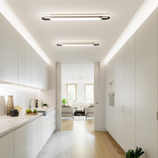 Modern kitchen with white cabinets and a view into a living room.