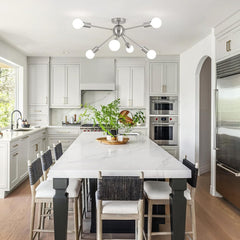 Modern kitchen with white marble countertop, stainless steel appliances, and wooden flooring.