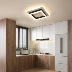 Modern kitchen with wooden cabinets, white appliances, and a ceiling light fixture.