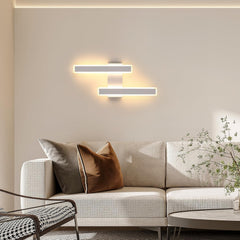 Modern living room with a beige sofa, decorative pillows, and wall lights.