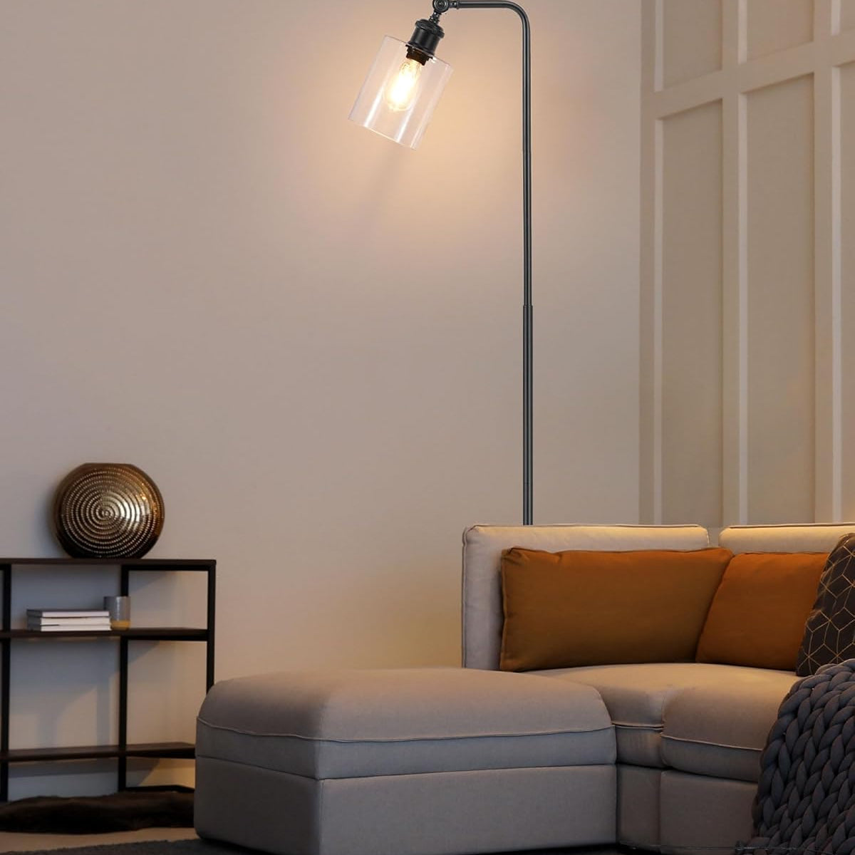 Modern living room with a floor lamp, sofa, and decorative items.