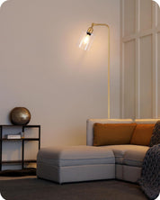 Modern living room with a gray sectional sofa, gold floor lamp, and decorative items.