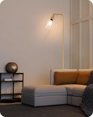 Modern living room with a gray sectional sofa, gold floor lamp, and decorative items.