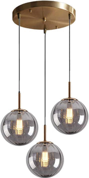 Modern pendant light fixture with three glass shades and gold accents on a white background
