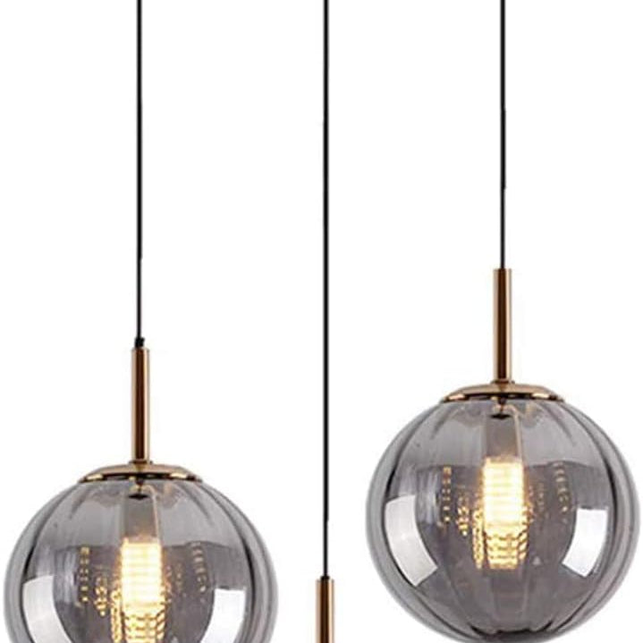 Modern pendant light fixture with three glass shades and gold accents on a white background