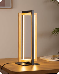 Modern table lamp with wooden frame and black base on a wooden surface.
