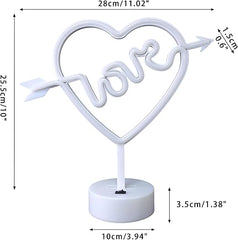 Neon sign shaped like a heart with the word 'love' inside, on a stand against a pink background.