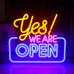 Neon sign with 'Yes! We Are Open' text in a dark setting