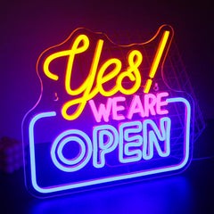 Neon sign with 'Yes! We Are Open' text on a dark background