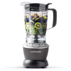 Nutribullet blender with fruits and vegetables inside on a white background