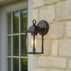 Outdoor wall light fixture on a stone wall next to a window