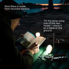 Person reading a book with Silva Glow light on a beach at night