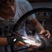 Person working on a bicycle wheel with a close-up of the gear mechanism.