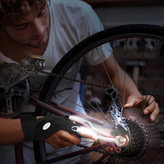 Person working on a bicycle wheel with a close-up of the gear mechanism