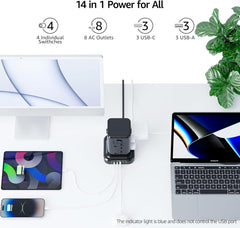 Power adapter with multiple ports connected to electronic devices on a white surface with a plant in the background.