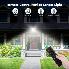 Remote control motion sensor light being used on a house exterior with a hand holding a remote.