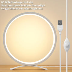 Round LED light with USB cable on a beige background