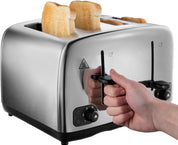 Silver toaster with slices of bread being inserted, hand holding the lever.