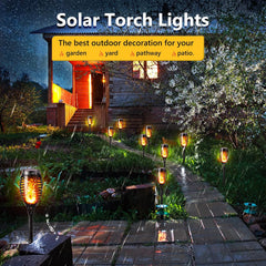 Solar torch lights illuminating a garden pathway with a house in the background.