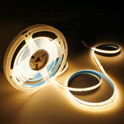 Spool of LED strip light with warm glow on a dark background