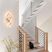 Staircase with wooden steps and black railings, featuring a black cat sitting on a step.