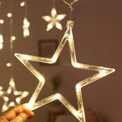 Star-shaped LED light held by a hand with more lights in the background