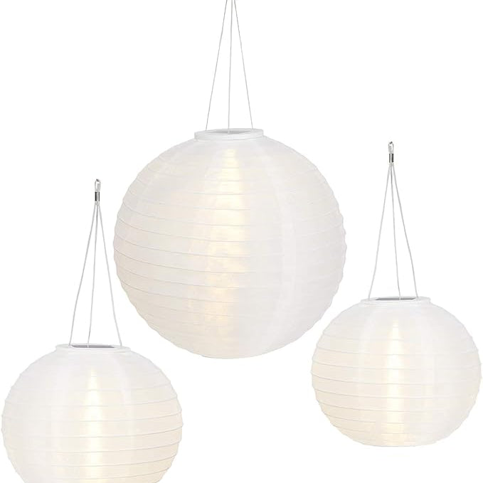 Three white spherical pendant lights hanging against a white background