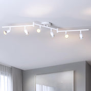 Track lighting fixture on a ceiling with four lights on a white ceiling.