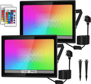 Two RGB LED flood lights with remote controls and power cables on a white background