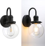 Two black wall sconces with clear glass shades on a white background