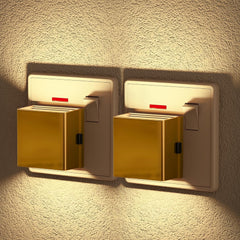 Two gold night lights on a textured wall.