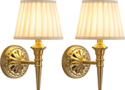 Two gold wall sconces with white lampshades on a white background