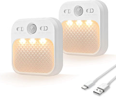 Two motion sensor lights with a USB cable on a white background