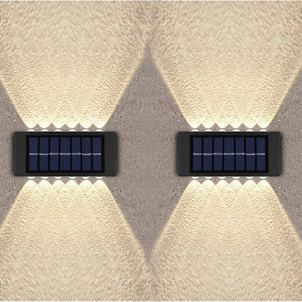 Two solar-powered wall lights on a textured wall.