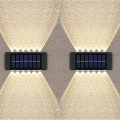Two solar-powered wall lights on a textured wall.