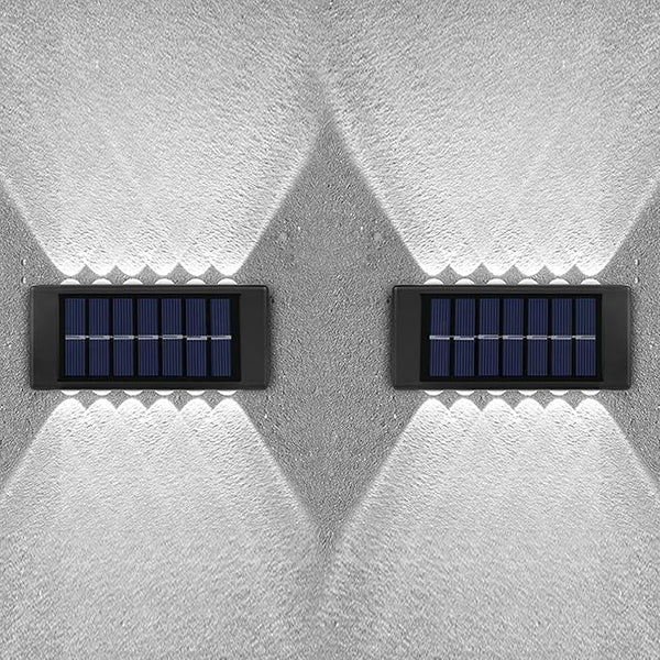 Two solar panels mounted on a textured white wall.