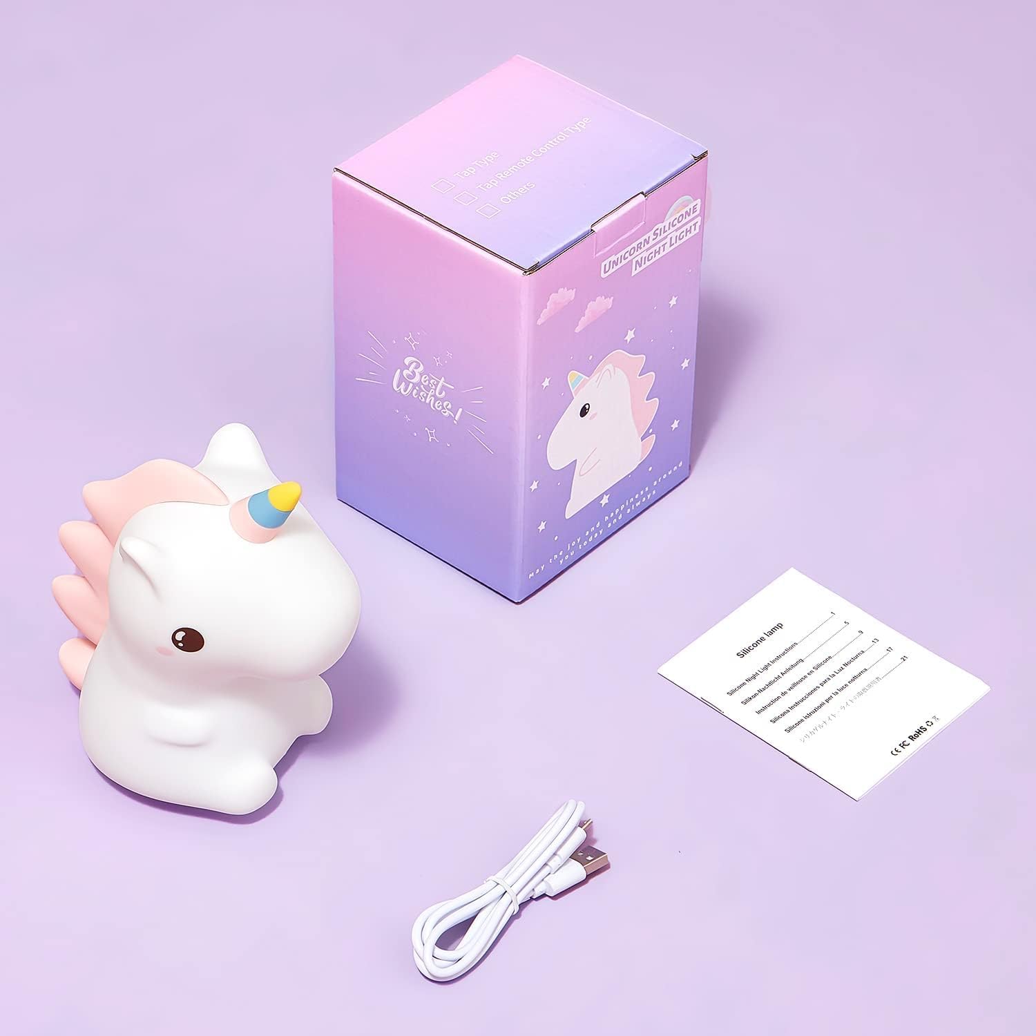 Unicorn-shaped night light with packaging, USB cable, and instruction sheet on a purple background