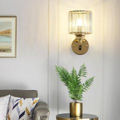 Wall-mounted gold sconce with a plant on a table in a living room setting.