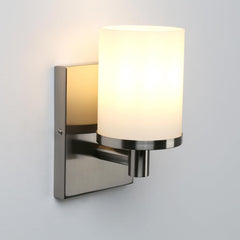 Wall-mounted light fixture with a white glass shade on a gray background